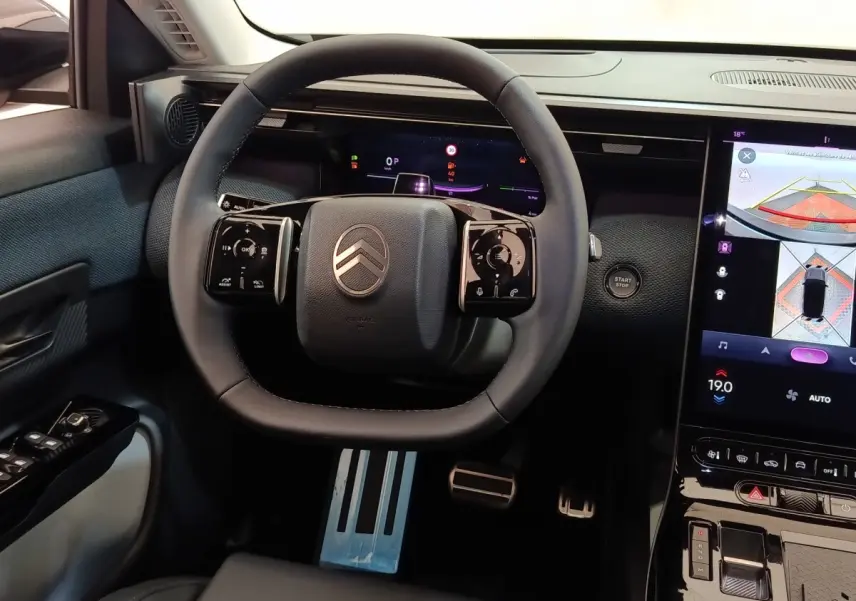 Vue intérieure centrée sur le volant cuir multifonctions et l'écran tactile du tableau de bord de la Citroën C5 Hybride 2025.