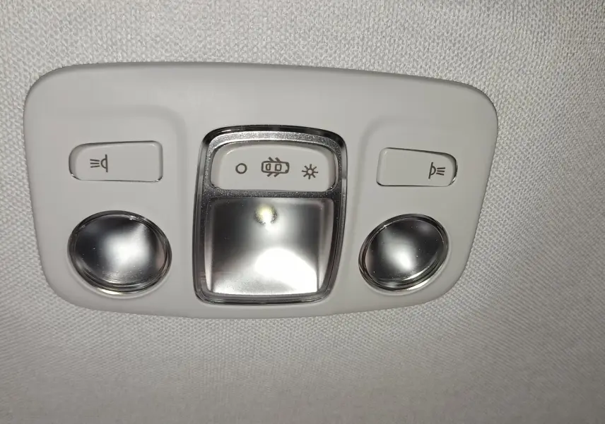 Plafonnier intérieur gris clair avec commandes d’éclairage et lampes de lecture rondes dans une Citroën C5 hybride 2025.