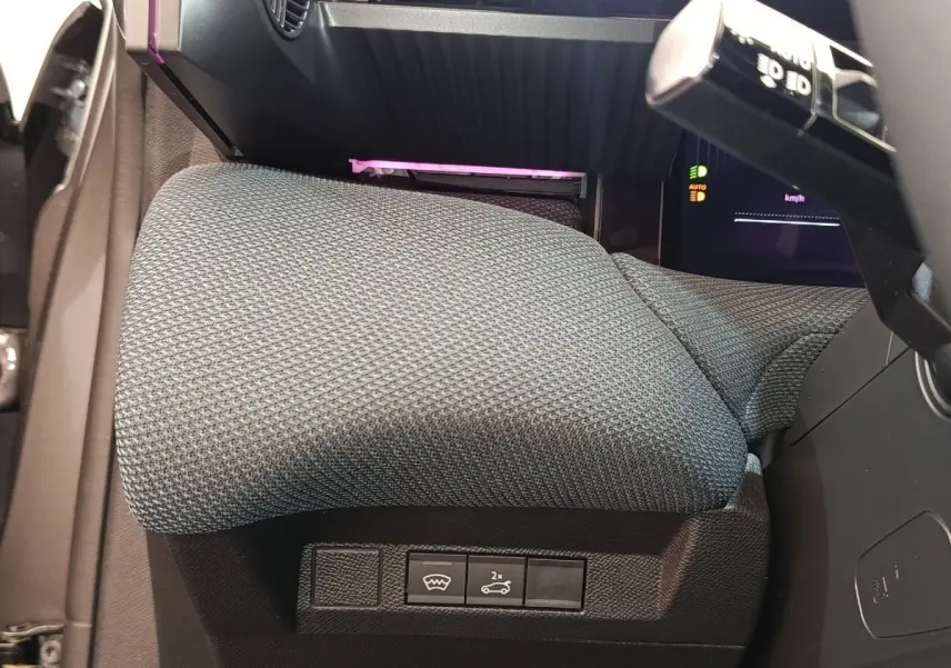 Gros plan sur la commande d'ouverture du coffre et dégivrage, siège conducteur gris foncé de la Citroën C5 hybride 2025.