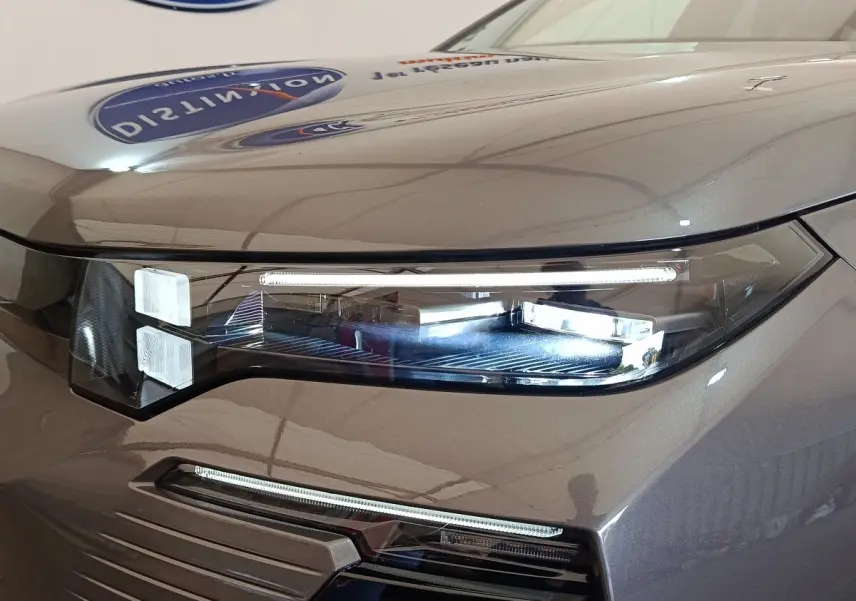 Gros plan sur le phare avant droit LED d'une Citroën C5 hybride gris foncé, soulignant les lignes modernes du capot.