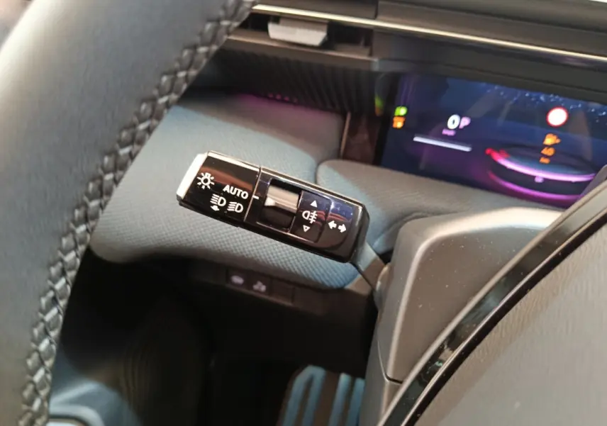 Gros plan sur la commande des phares et clignotants à gauche du volant dans l’habitacle de la Citroën C5 hybride 2025.