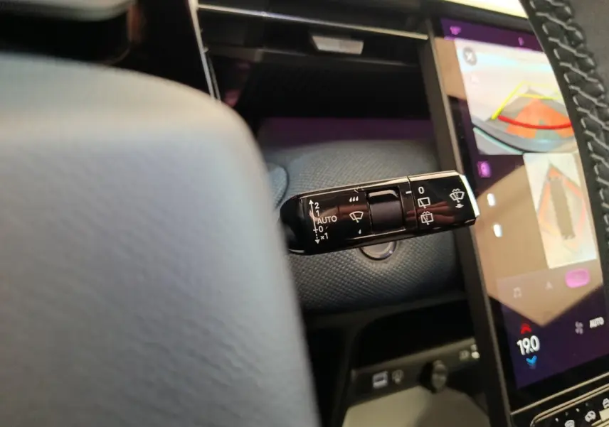 Gros plan sur la commande d’essuie-glace à gauche du volant dans l’habitacle gris foncé d’une Citroën C5 Hybride 2025.