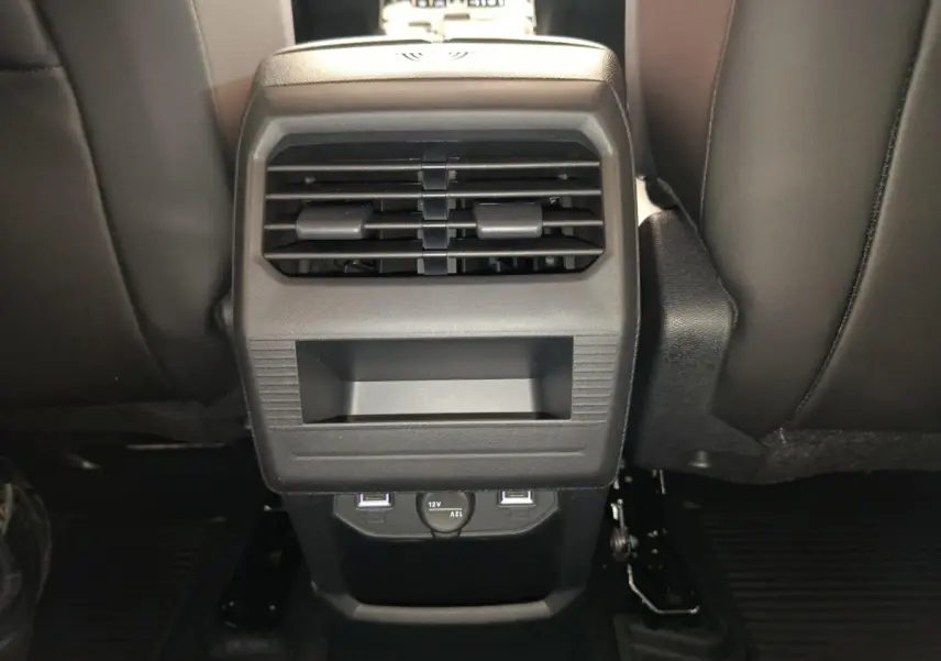 Vue rapprochée de la console arrière noire avec bouches d’aération et prises USB du Citroën C5 Hybride gris foncé.