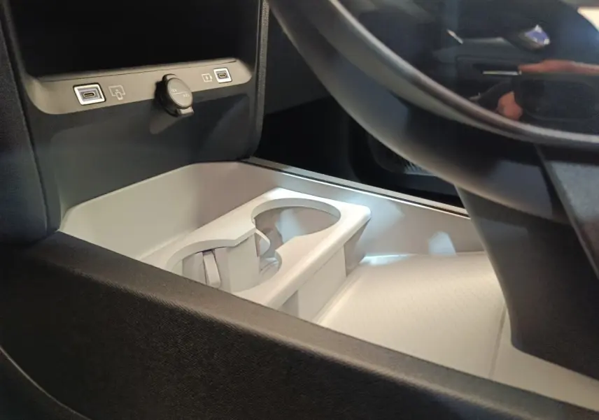 Gros plan sur la console centrale claire avec porte-gobelets et prises USB dans une Citroën C5 Hybride 2025.