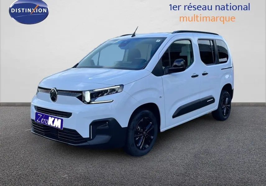 Vue 3/4 avant droite du Citroën Berlingo Multispace blanc glacier avec jantes noires et protections latérales noires.