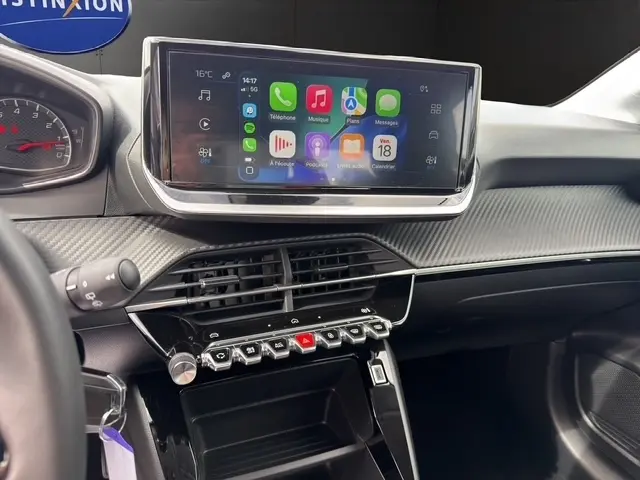 Vue intérieure du tableau de bord de la Peugeot 208 gris foncé, avec écran tactile central et commandes piano.