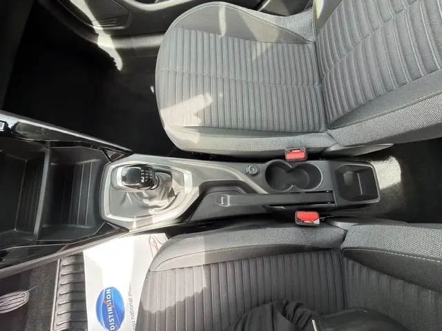 Vue plongeante sur la console centrale et les sièges avant gris foncé de la Peugeot 208 100CH S&S Active 2024 avec boîte manuelle.