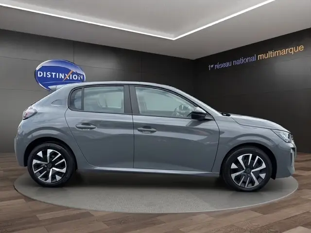 Peugeot 208 gris foncé vue de profil côté gauche, avec jantes alliage et poignées ton caisse visibles.