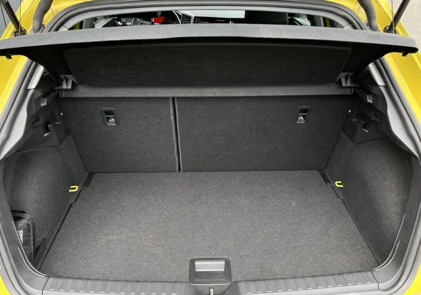 Coffre ouvert vu de l'arrière d'une Audi A1 Allstreet jaune Python, montrant un espace de chargement propre et spacieux.