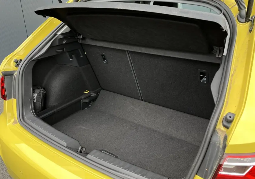 Coffre ouvert vu de l'arrière droit d'une Audi A1 Allstreet jaune Python, montrant l'espace de chargement vide.
