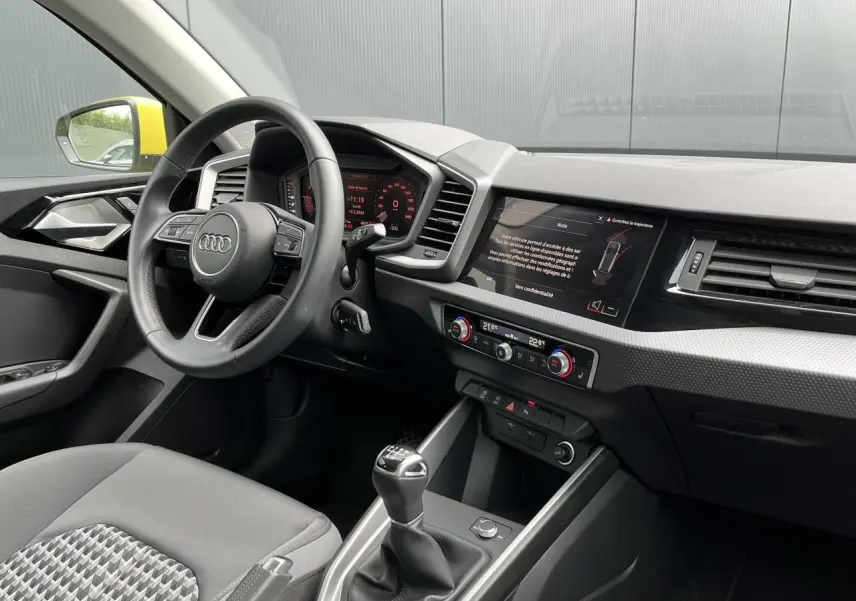Intérieur Audi A1 Allstreet 2022 vu côté conducteur, volant cuir, écran tactile et levier de vitesse manuel.