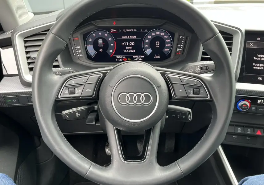 Vue intérieure centrée sur le volant cuir multifonctions et le tableau de bord avec écran tactile de l'Audi A1 Allstreet 2022.