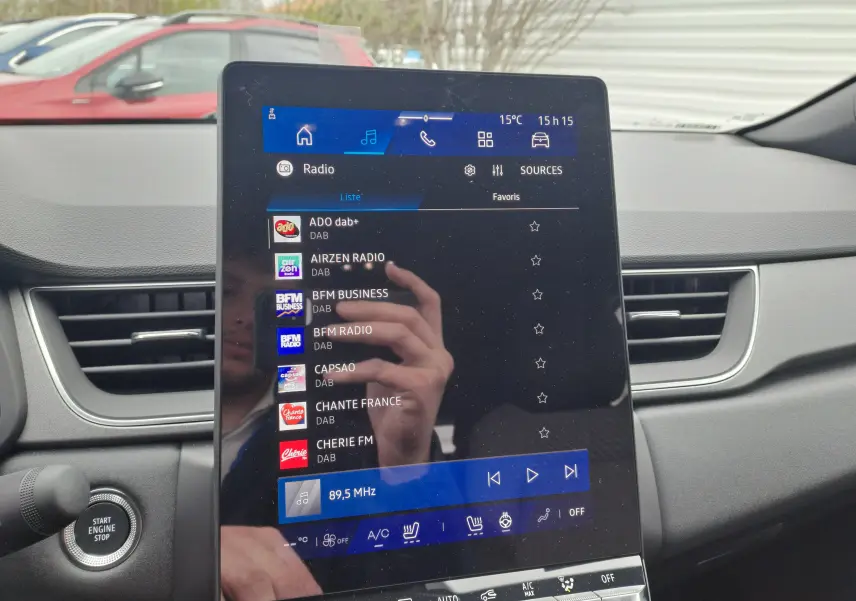 Écran tactile central du tableau de bord du Renault Symbioz gris Cassiope, avec commandes radio et climatisation visibles.