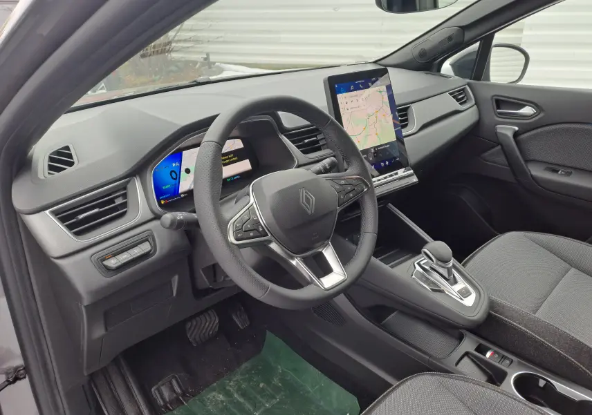 Intérieur de la Renault SYMBIOZ 2024, vue côté conducteur, tableau de bord numérique et écran tactile central visibles.