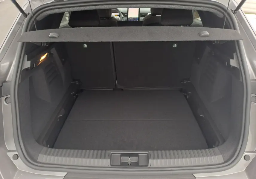 Coffre ouvert vu de l'arrière d'une Renault Symbioz gris Cassiope, avec cache-bagages et intérieur noir.