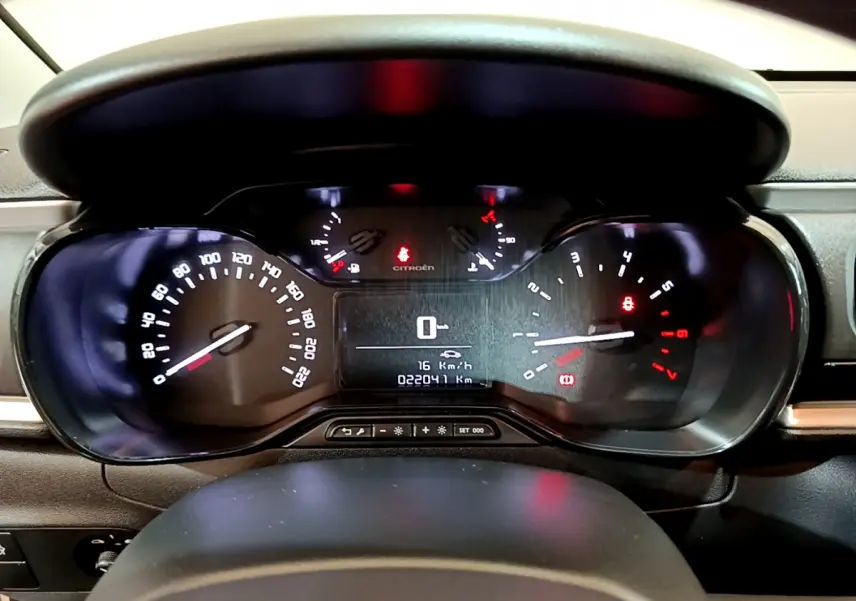 Tableau de bord de Citroën C3 blanc 2018, affichage numérique au centre et compteurs analogiques éclairés.