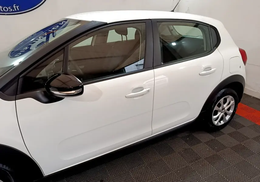 Profil côté gauche d'une Citroën C3 blanche 2018 avec rétroviseurs noirs et poignées de porte assorties.