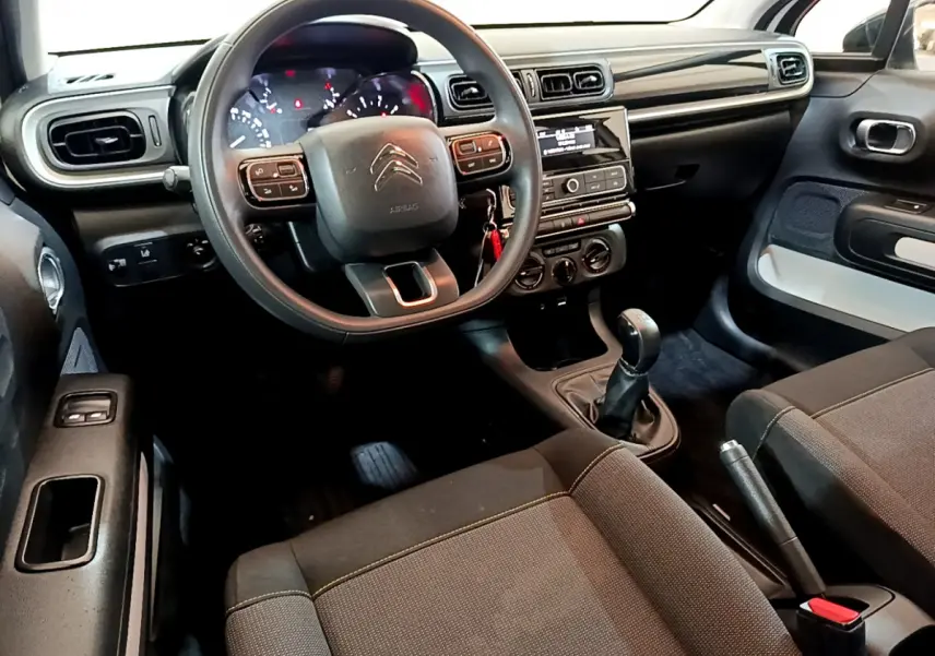 Intérieur de la Citroën C3 PureTech 68 BVM Feel 2018, vue avant côté conducteur avec tableau de bord noir et volant multifonctions.