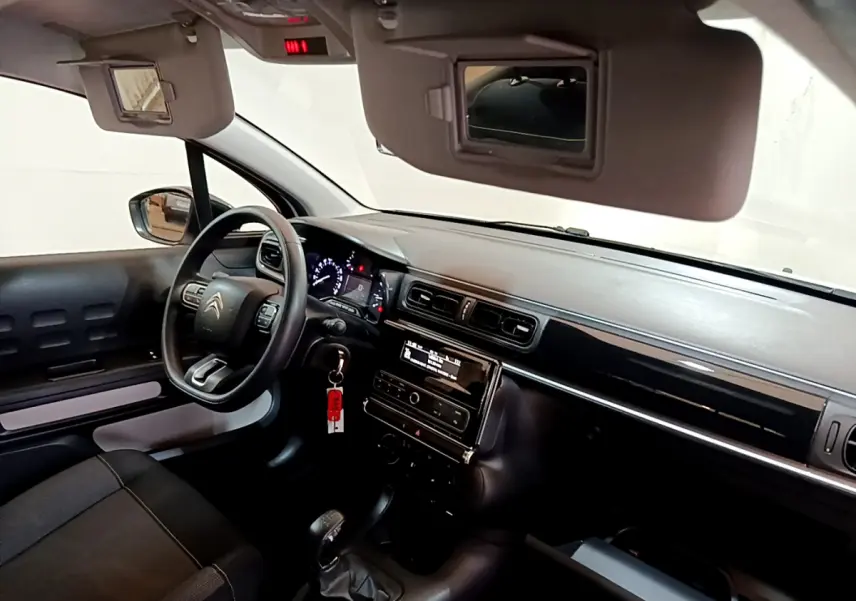 Intérieur avant droit de la Citroën C3 blanche, volant multifonctions, tableau de bord et écran central visibles.