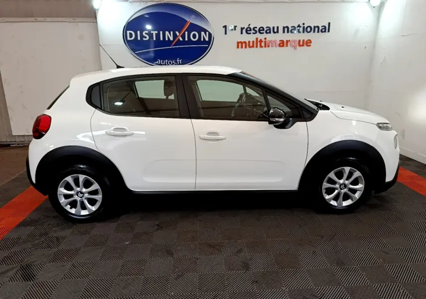 Profil côté gauche d'une Citroën C3 blanche PureTech 68 BVM Feel, avec jantes alliage et protections noires sur les passages de roues.