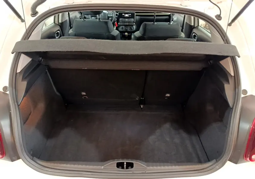 Vue arrière du coffre ouvert d'une Citroën C3 blanche de 2018, montrant l'intérieur spacieux et la banquette arrière.