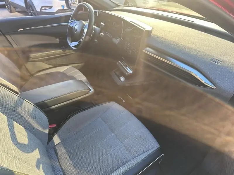 Intérieur de la Renault Mégane E-Tech 2023 vu côté conducteur, avec tableau de bord moderne et sièges gris.