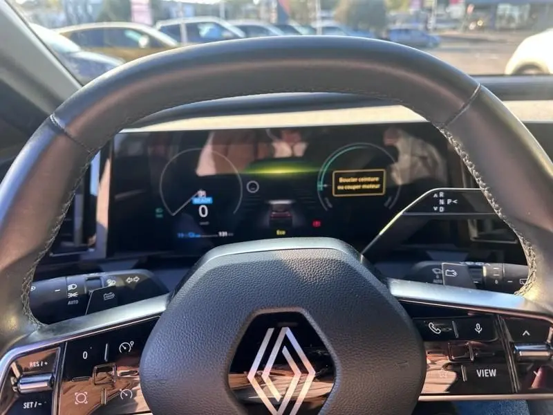 Vue intérieure centrée sur le volant et le tableau de bord numérique de la Renault Mégane E-Tech Electric 2023.