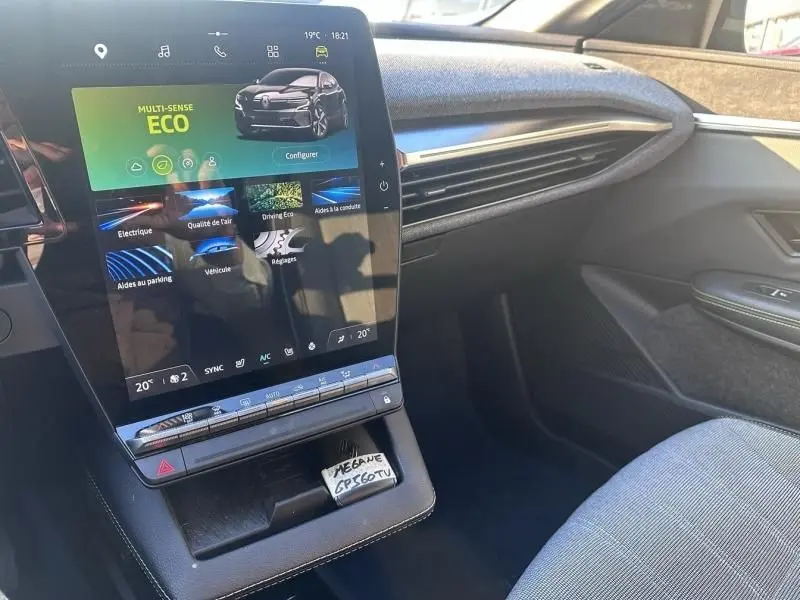 Vue intérieure côté passager de la Renault Mégane E-Tech Electric 2023 avec écran tactile central et finition moderne.