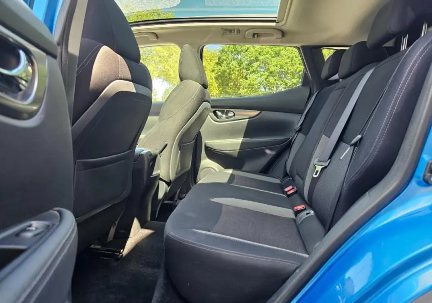 Vue intérieure arrière côté droit du Nissan Qashqai bleu 2019, montrant les sièges noirs et la porte ouverte.