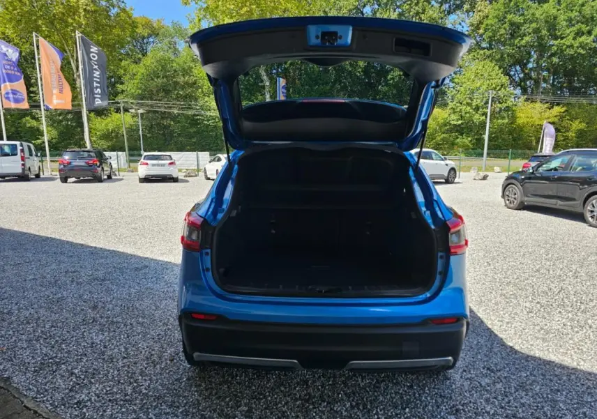 Vue arrière d’un Nissan Qashqai bleu 2019 avec coffre ouvert, montrant l’espace de chargement vide.