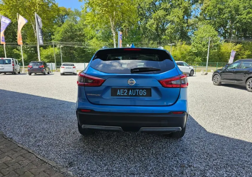 Vue arrière d'un Nissan Qashqai bleu 2019, avec feux arrière distinctifs et plaque AE2 AUTOS visible.