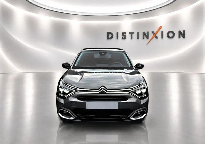 Citroën C4 gris vue de face dans un studio lumineux avec logo Distinxion en arrière-plan.