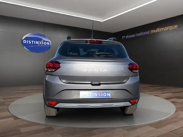 Vue arrière d'une Dacia Sandero Stepway gris foncé, avec feux arrière LED et logo DACIA lumineux au centre du hayon.
