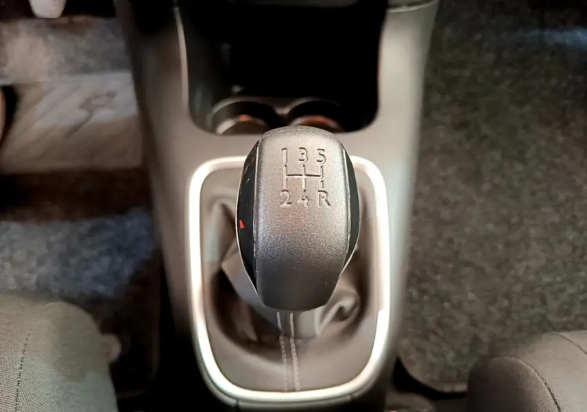 Gros plan sur le levier de vitesse manuel noir de la Citroën C3 gris foncé, entouré de garniture argentée.