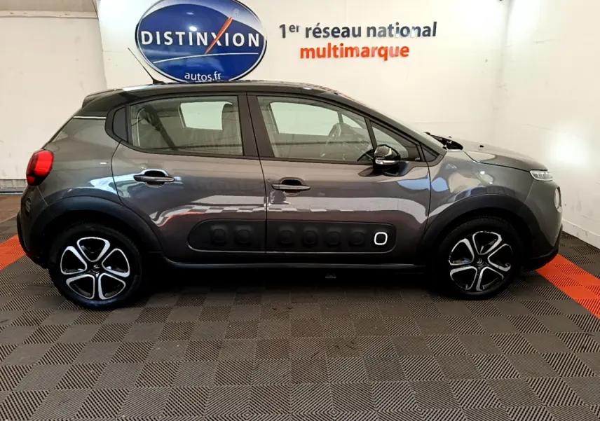 Profil côté gauche d'une Citroën C3 gris foncé 2019 avec protections latérales noires caractéristiques et jantes stylisées.