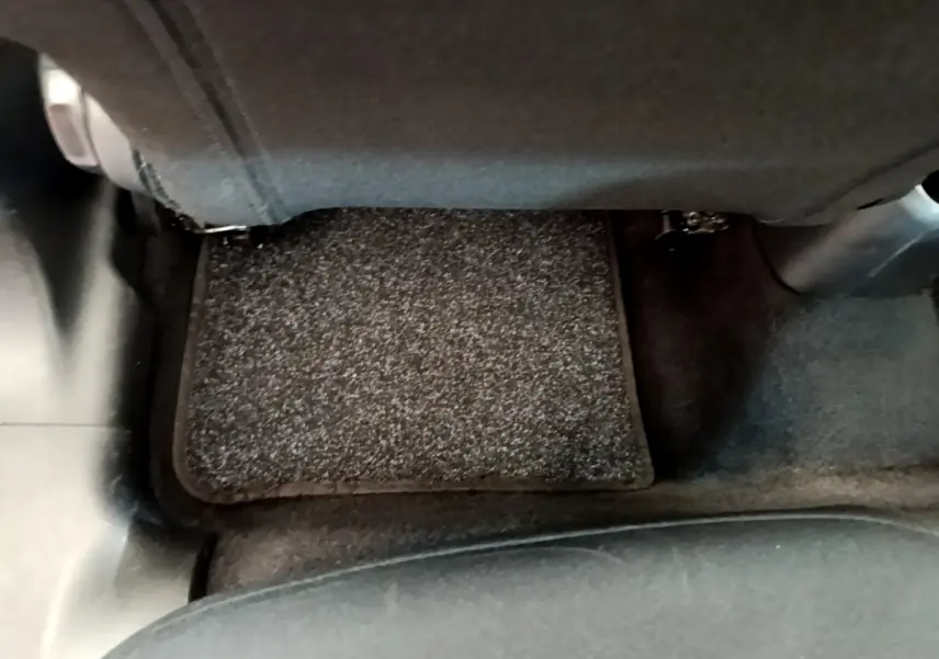 Vue du sol côté arrière droit avec tapis gris foncé sous le siège arrière d'une Citroën C3 2019 Shine