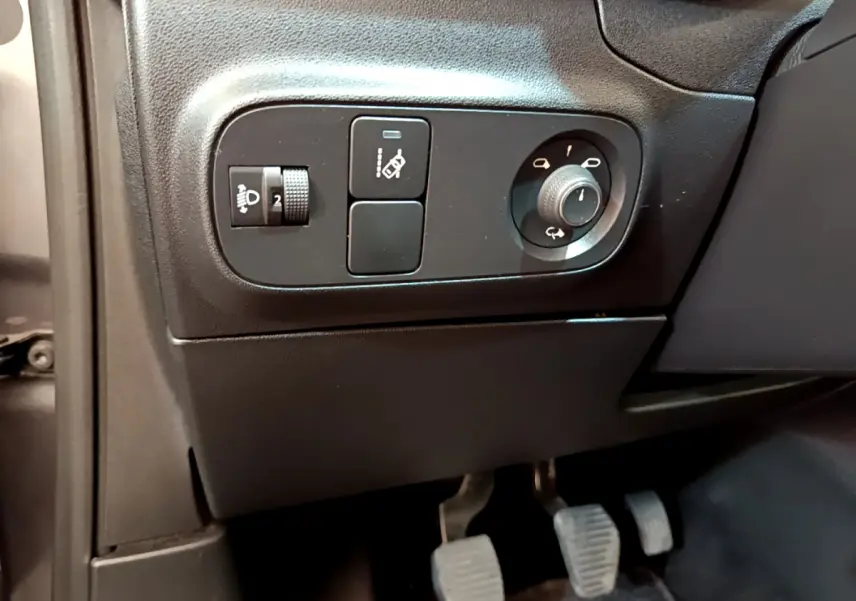 Détail du tableau de bord côté gauche avec commandes de réglage des phares et rétroviseurs sur Citroën C3 gris foncé 2019.