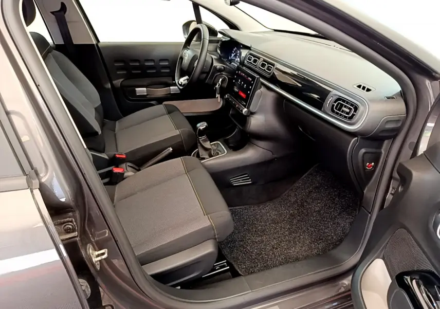 Intérieur avant droit de la Citroën C3 gris foncé 2019, avec tableau de bord noir brillant et écran tactile central.