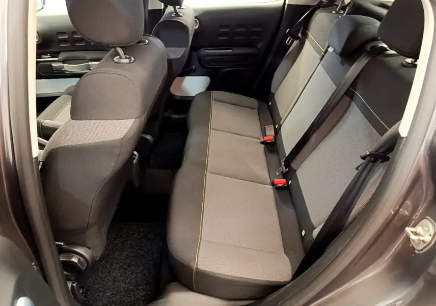 Vue intérieure côté droit sur la banquette arrière grise de la Citroën C3 PureTech 82 Shine 2019, avec ceintures visibles.