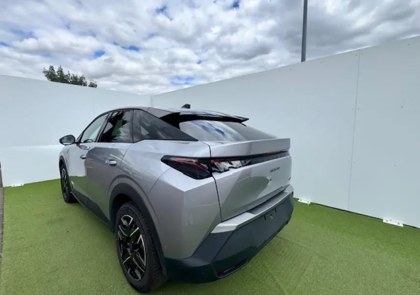 Vue 3/4 arrière gauche du Peugeot 3008 gris Artense avec toit noir, feux arrière à griffes LED et jantes alliage noires.