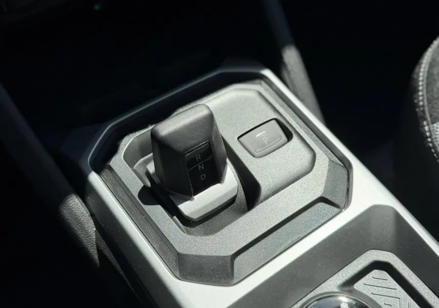 Gros plan sur la commande de boîte automatique du Dacia Duster Hybrid-G 150, finition intérieure gris anthracite.