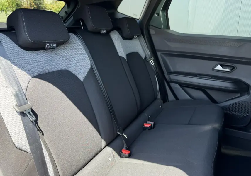 Vue côté droit des sièges arrière noirs et gris du Dacia Duster Hybrid-G 150 4X4 Journey avec ceinture et appuie-têtes.