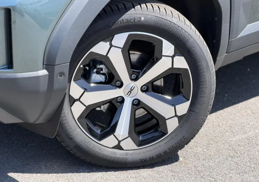 Gros plan sur la jante alliage 18 pouces noire et argent du Dacia Duster Vert Cèdre, avec pneu Continental visible côté avant droit.