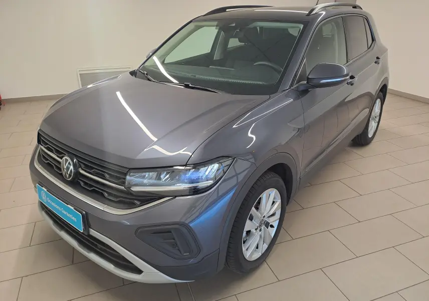 Volkswagen T-Cross gris cendré en vue 3/4 avant droit, avec calandre noire et jantes alliage argentées.
