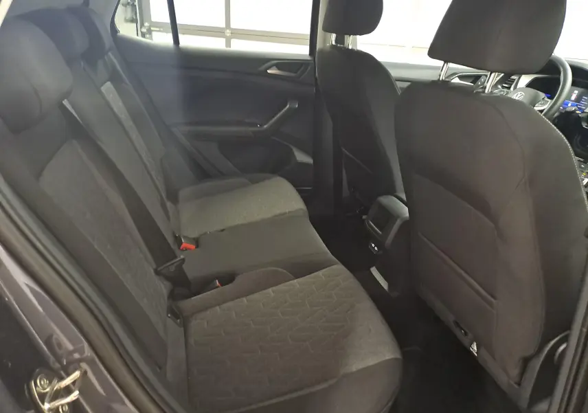 Vue intérieure côté gauche montrant les sièges arrière en tissu gris foncé du Volkswagen T-Cross 2025.