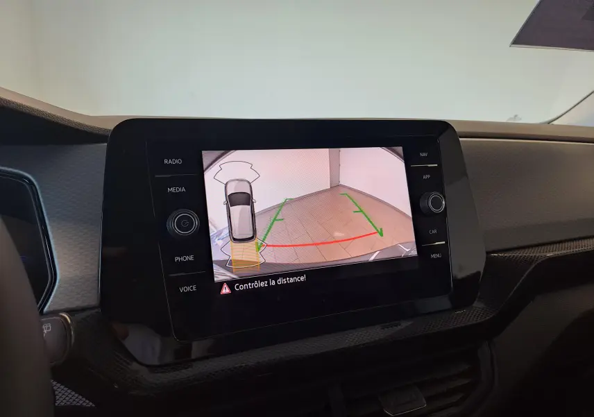 Écran intérieur montrant la caméra de recul avec vue arrière et lignes de guidage vertes et rouges.