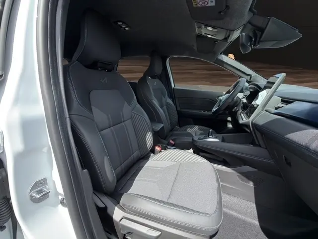 Vue intérieure côté gauche du Renault Captur blanc 2026, sièges avant noirs avec logo Alpine brodé, tableau de bord moderne.
