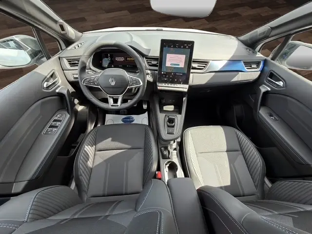 Vue intérieure avant du Renault Captur esprit Alpine blanc, avec tableau de bord moderne et écran tactile central vertical.