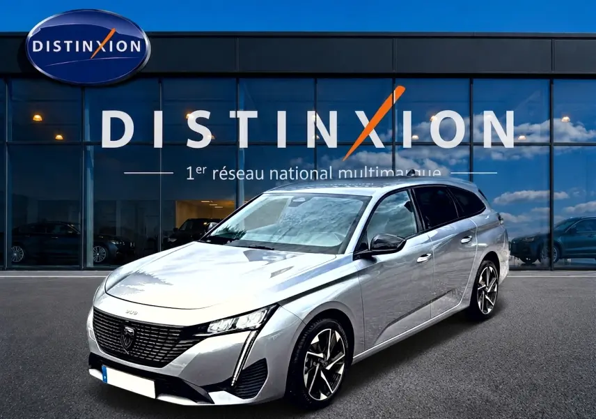 Peugeot 308 SW gris vue 3/4 avant droit, avec jantes alliage et calandre noire distinctive.
