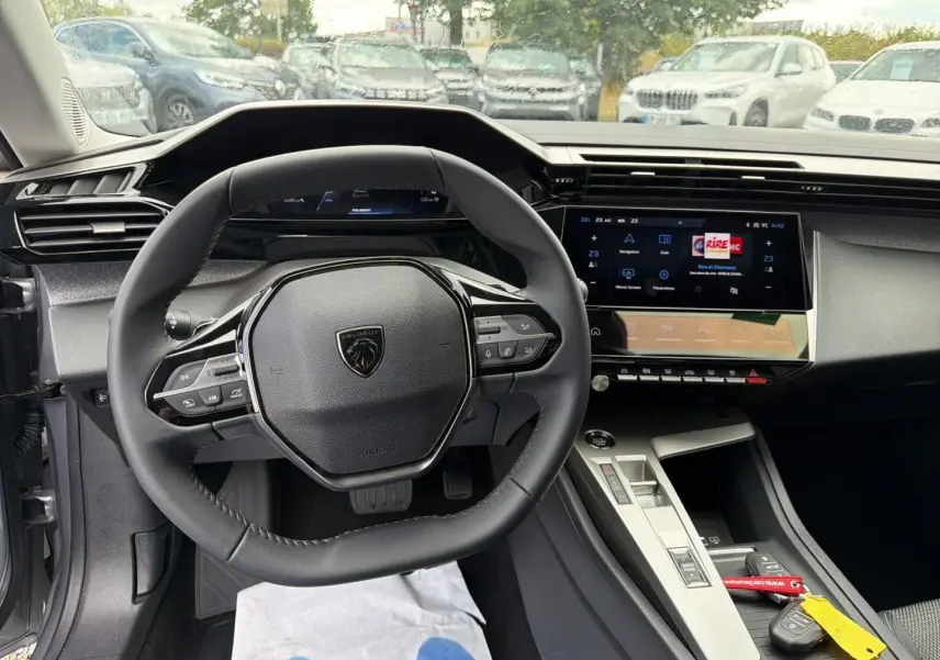 Vue intérieure centrée sur le volant multifonction et l’écran tactile du tableau de bord d’une Peugeot 308 SW 2025.